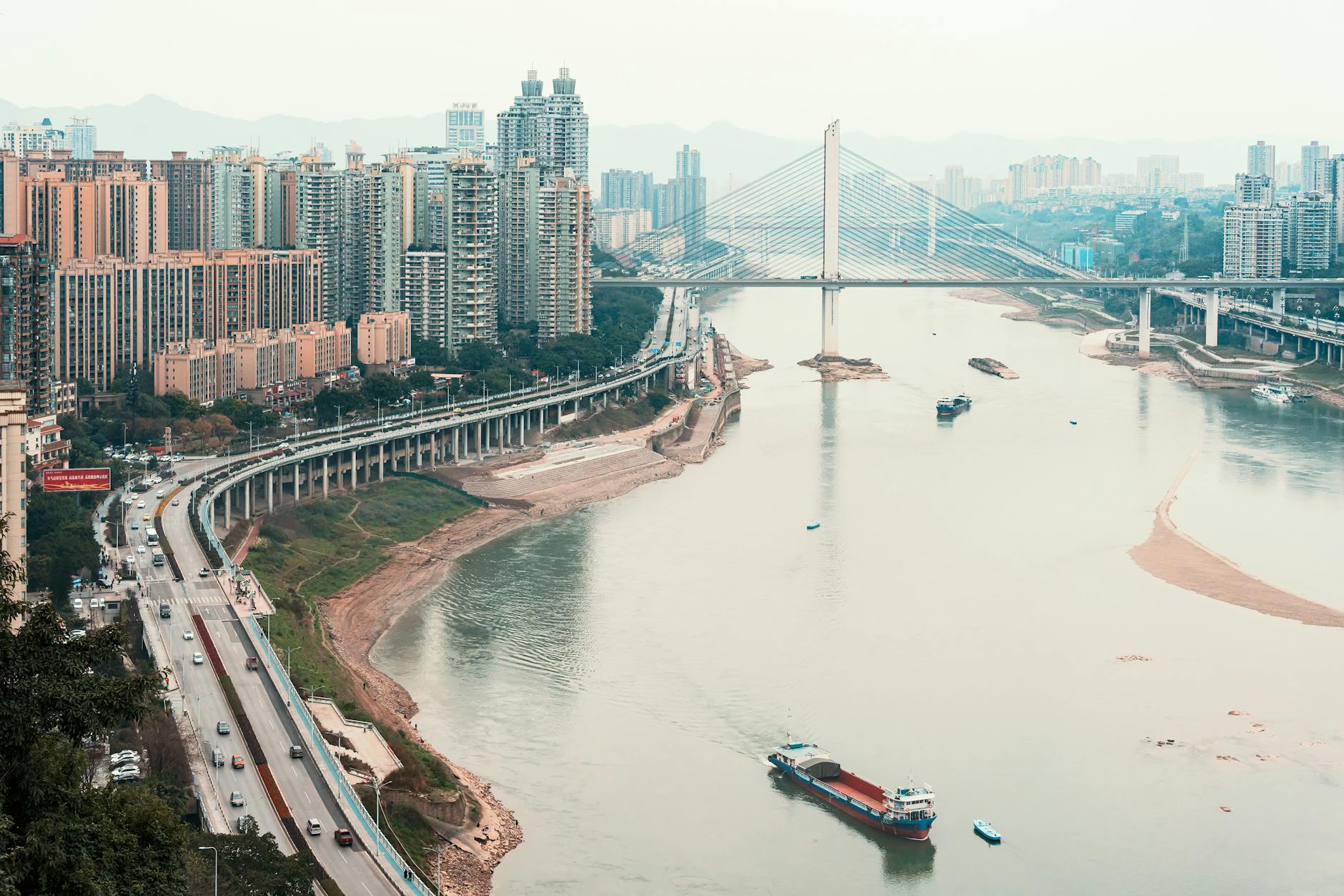 Cityscape with modern skyline, bridge, and river in daylight