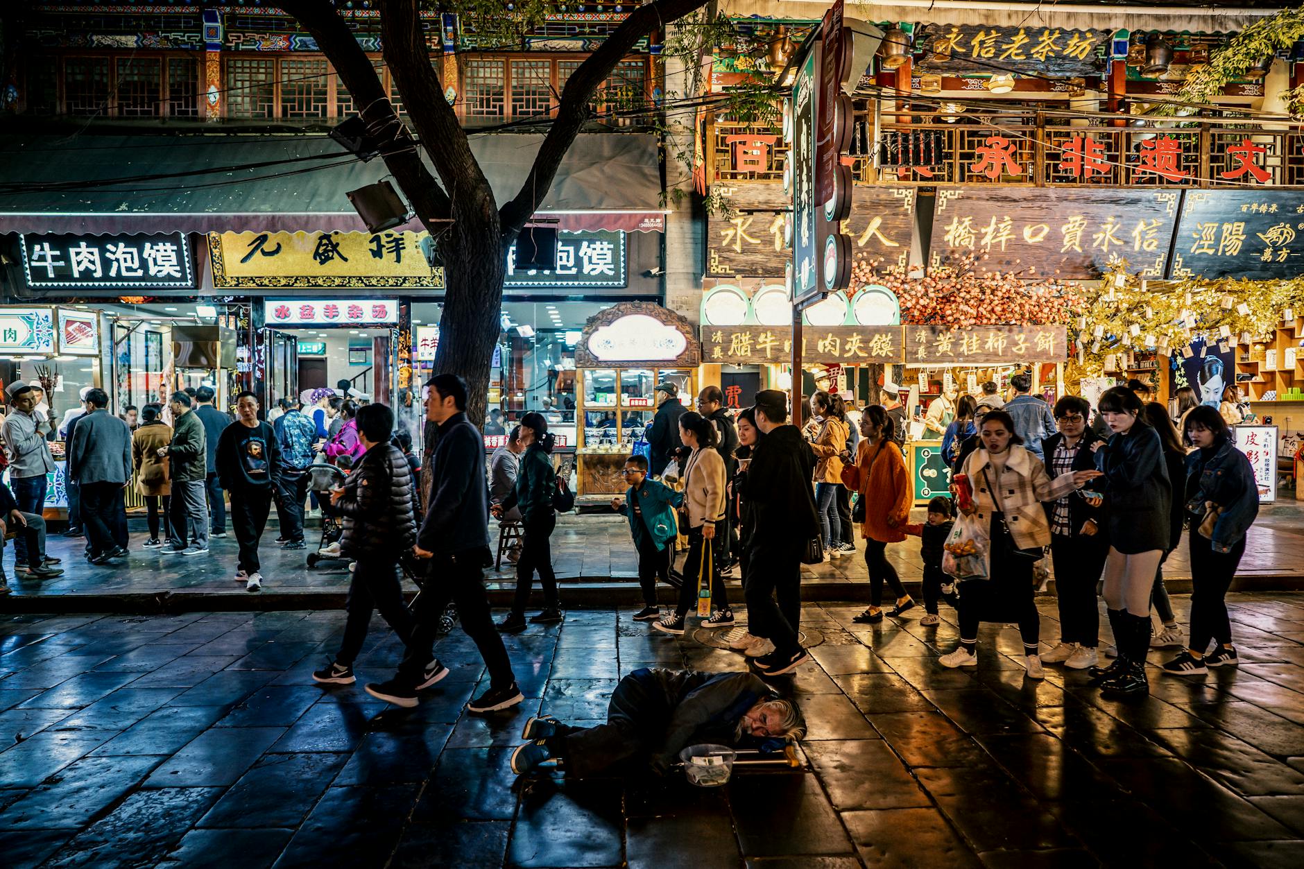 Vibrant night scene at Xi'an street market with people walking and colorful signages.