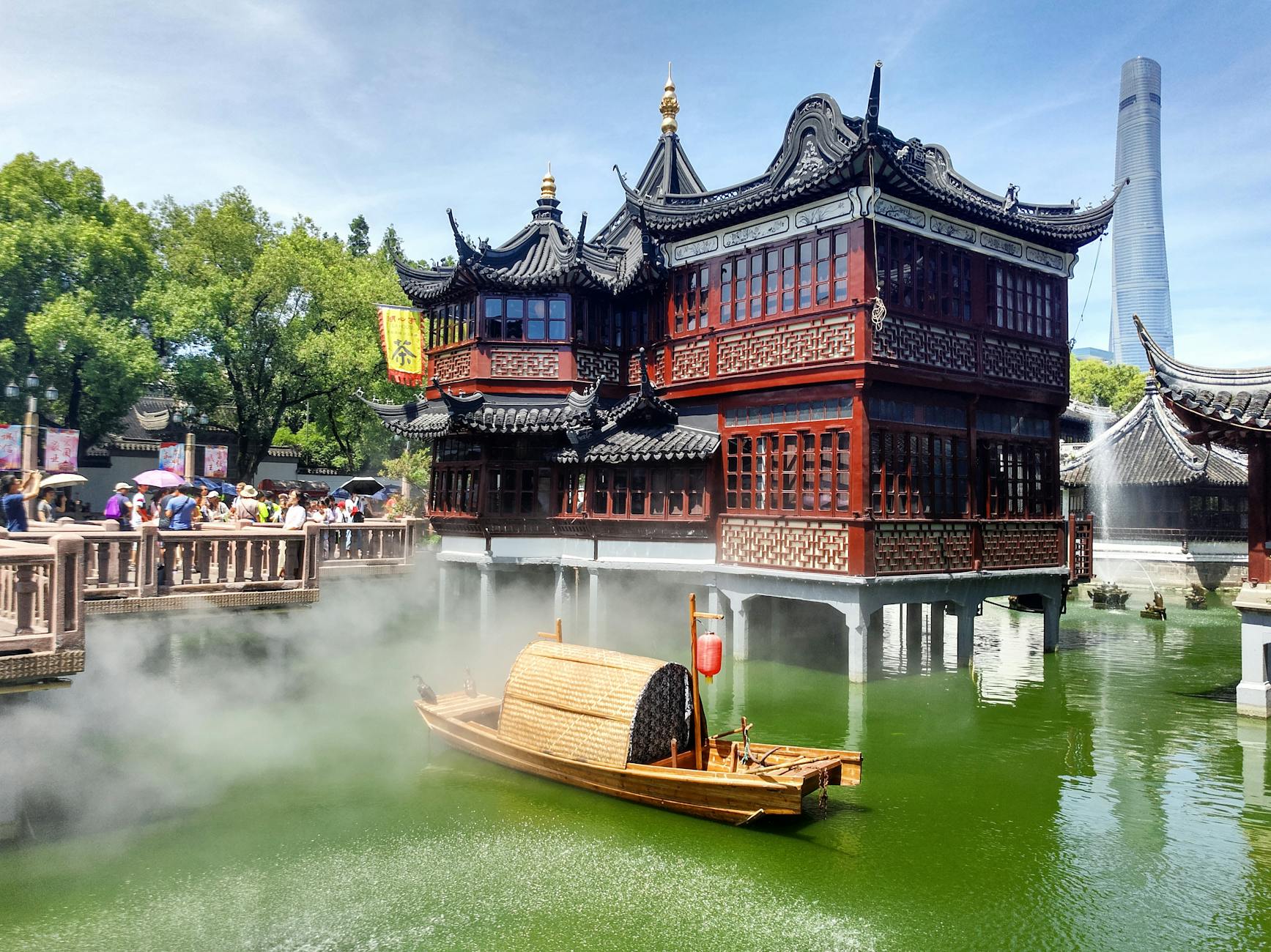 Elegant traditional architecture and boat on a serene river in Shanghai, China.