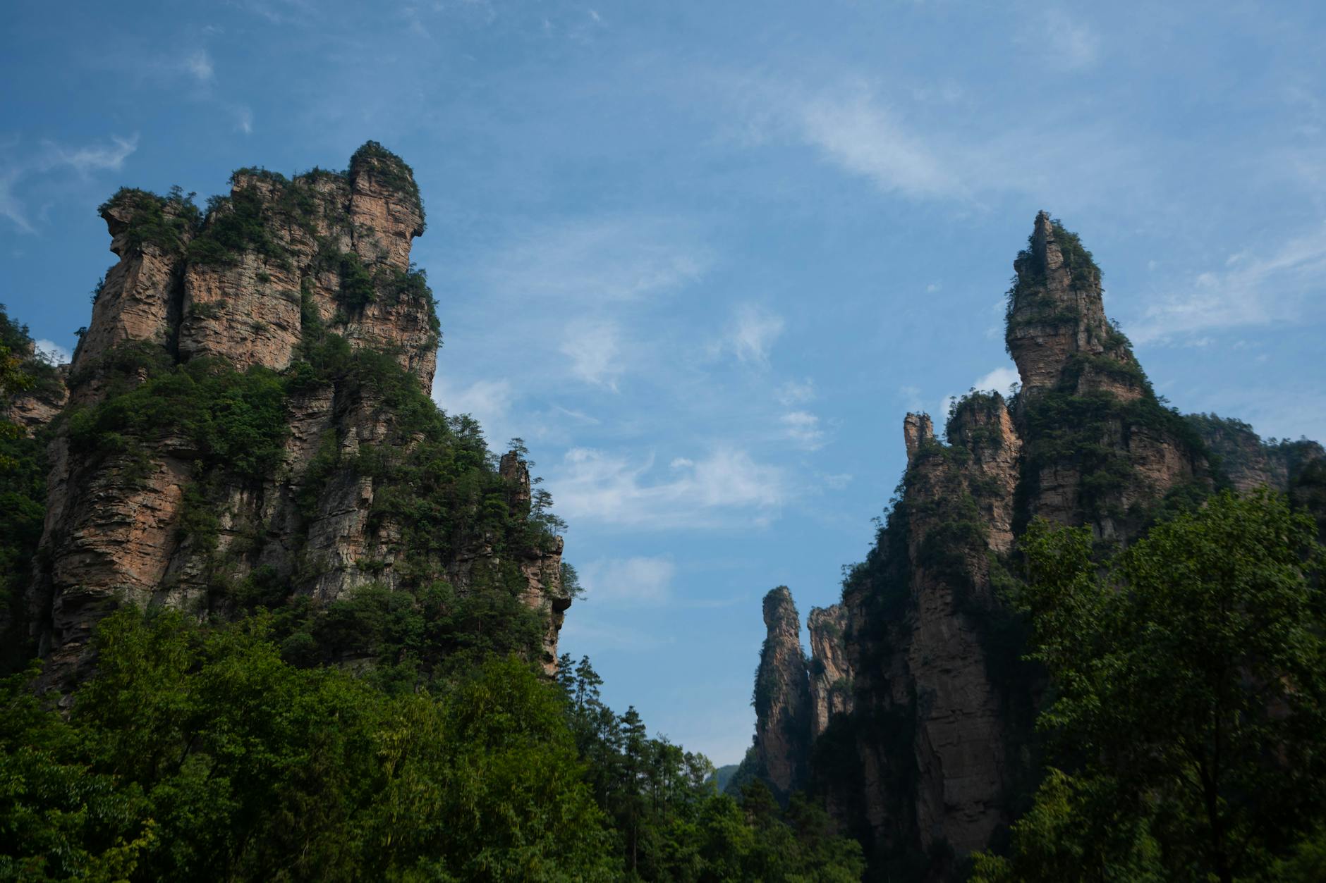 Explore the majestic sandstone pillars of Zhangjiajie, Hunan, China under a clear blue sky.
