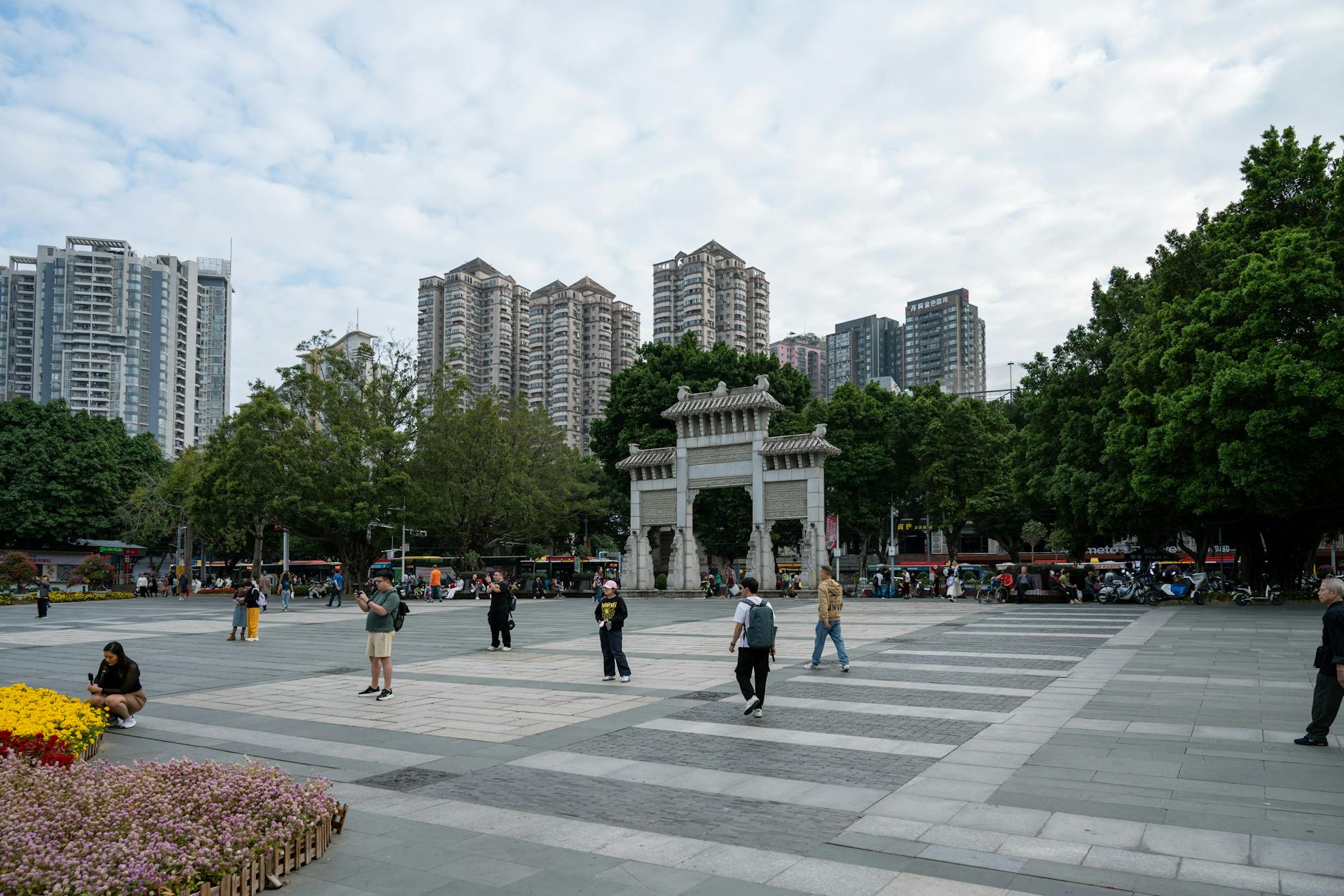 Street view in Guangzhou city featuring a traditional gate and modern skyscrapers.