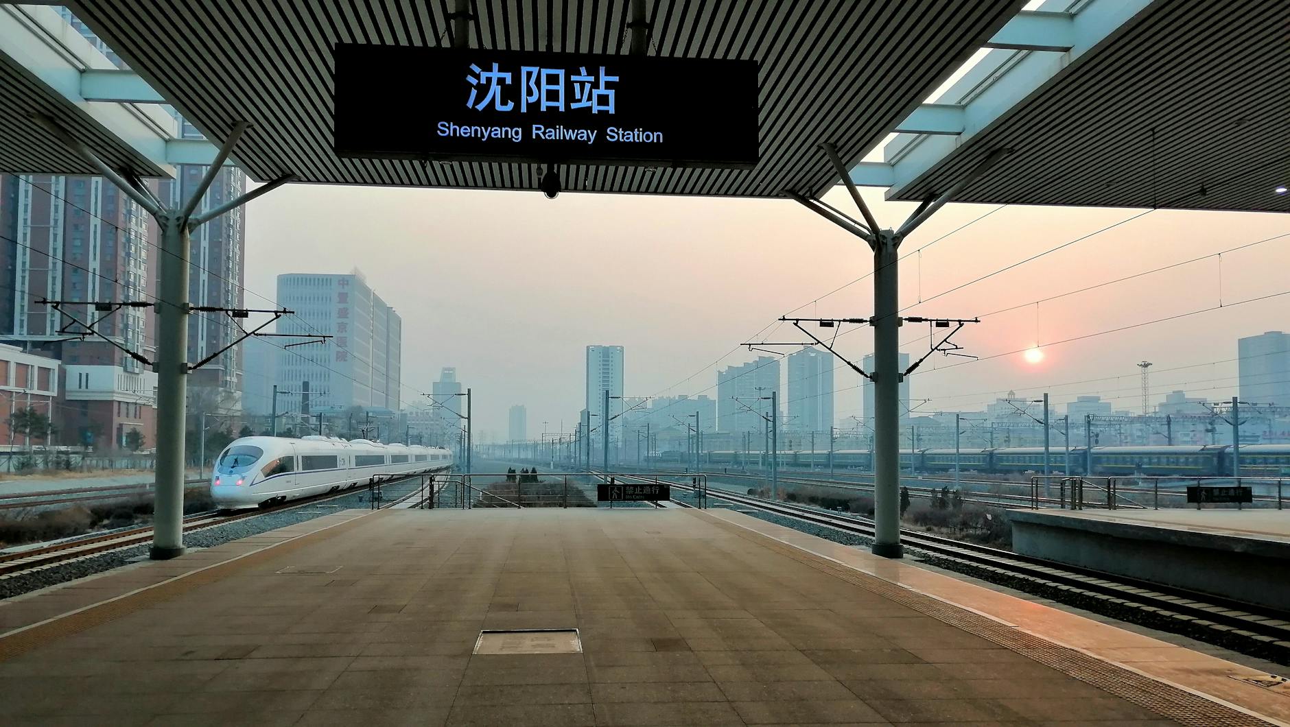 High-speed train approaches Shenyang Railway Station at sunset in China.