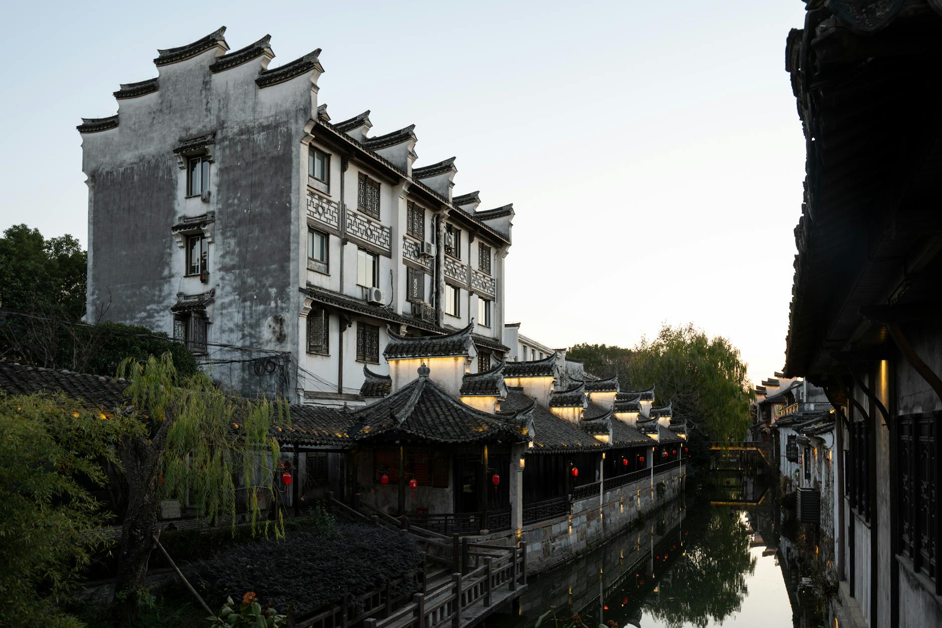 Scenic view of traditional Chinese architecture along a canal at sunset in Shanghai, China.