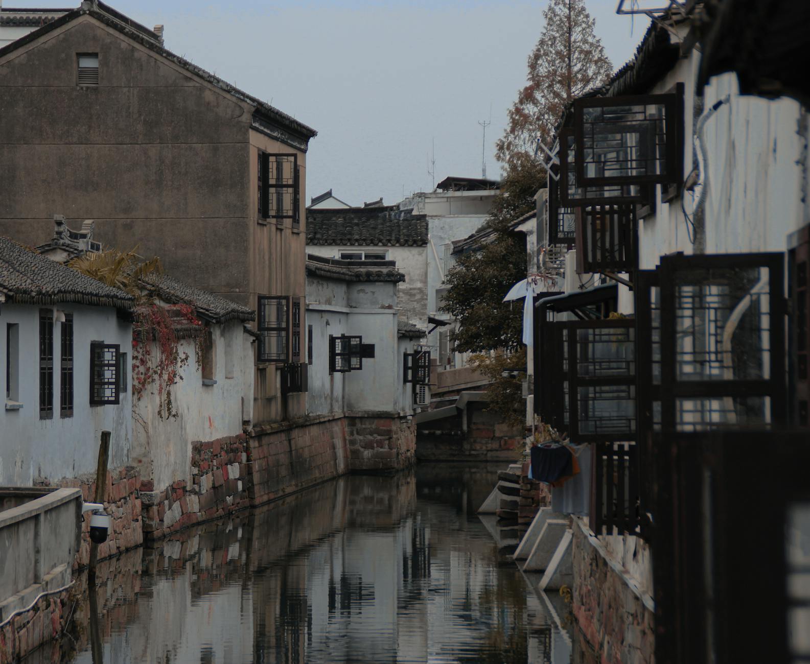 Charming architecture along a narrow canal in Suzhou, China, reflecting historical charm.